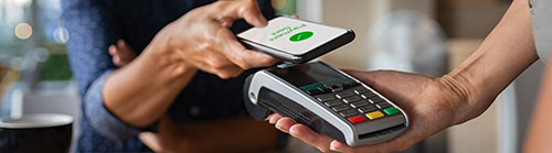 A photo showing a transaction between a smartphone and POS terminal